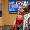Kurt Francois and a couple next to a print from Grey Fox during exhibition
